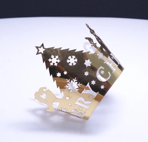 Detail of laser-cut gold mirror paper cupcake wrappers with Christmas tree and snowflake designs