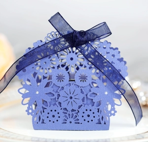 Elegant purple hollow-out paper candy gift box with floral laser-cut pattern and blue ribbon bow