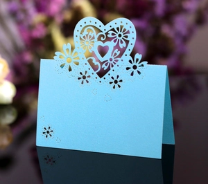 Dettaglio di cuori e fiori intagliati al laser su un segnaposto azzurro traforato