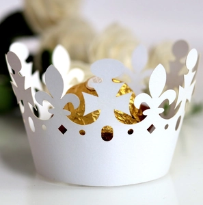Detailed laser-cut white crown paper cupcake wrapper with intricate hollow lace pattern