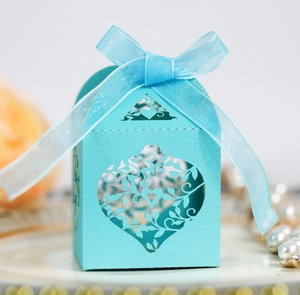 Close-up of laser-cut heart pattern on sky blue wedding favor box with ribbon