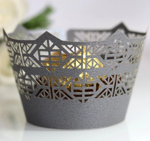 Macro detail of laser-cut crown cupcake wrapper in metallic dark grey finish
