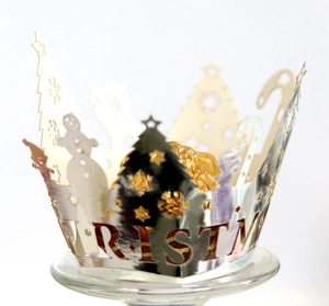Detail of silver laser-cut cupcake wrapper with Christmas tree patterns and text