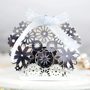 Elegant silver laser-cut wedding favor box with a light blue silk ribbon and floral hollow design