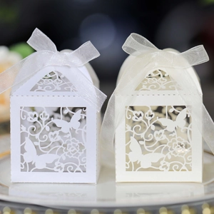 Close-up of laser-cut butterfly gift boxes with silk ribbons for wedding favors