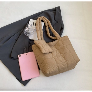 Gros plan sur le sac cabas matelassé kaki avec coutures en losange et mini pochette assortie
