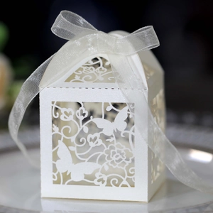 Detailed close-up of laser-cut butterfly patterns on a white pearlescent paper favor box