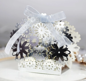 Detailed laser-cut silver candy box with flower patterns and grey silk ribbon bow