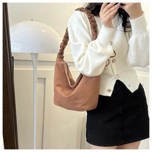 Close-up of brown canvas hobo bag with unique scrunchie handle and minimalist aesthetic