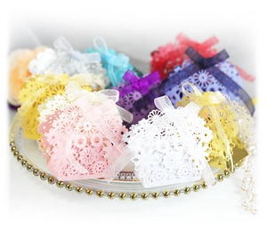 Detailed laser-cut floral wedding candy boxes in multiple colors with ribbon bows