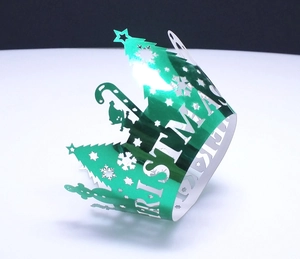 Detail showing green laser-cut Christmas cupcake wrappers with metallic finish and trees