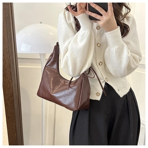 Detail einer dunkelbraunen Falten-Halbmondtasche in einem Spiegel-Selfie-Outfit-Look