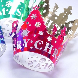 Close-up of laser-cut Christmas crown cake wrappers with snowflake and tree patterns