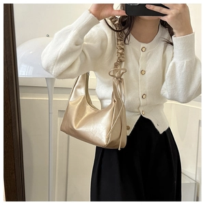 Detail of champagne gold crescent hobo bag with trendy gathered cloud-style handle