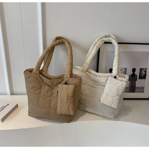 Gros plan du motif matelassé et de la petite pochette sur un grand sac fourre-tout