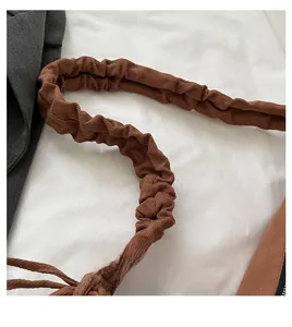 Detail of a brown pleated handle on a casual canvas bag with romantic time lettering