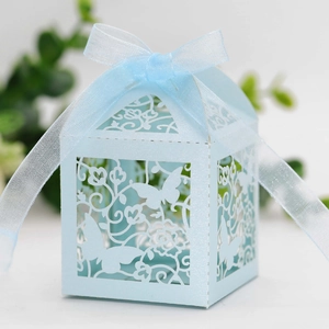 Detail of light blue laser-cut wedding favor box with butterfly pattern and organza ribbon
