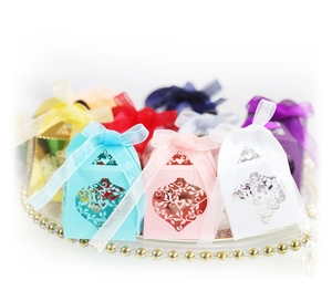 Laser-cut hollow heart gift boxes in various colors with elegant ribbon bows for weddings