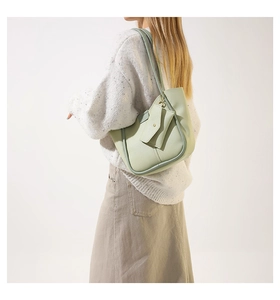 Detail of mint green PU leather shoulder bag featuring a matching coin purse on model