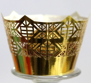 Detail of laser-cut hollow pattern on golden cupcake wrapper for party decoration