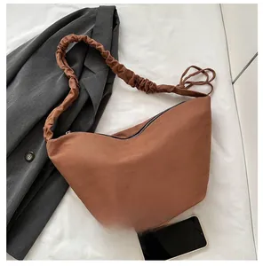 Detail of brown canvas dumpling bag showing large capacity for mobile phones