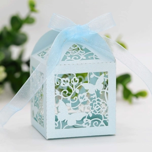 Detail of light blue laser-cut candy box with butterfly floral patterns and ribbon bow