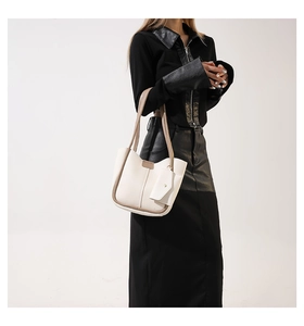 Close-up of minimalist two-tone leather tote bag with a small matching coin purse