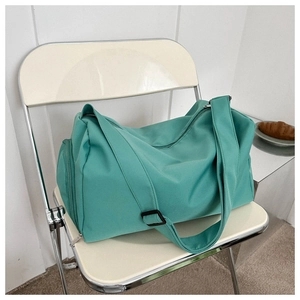 Detail of mint green tote bag showing waterproof nylon texture and side shoe compartment