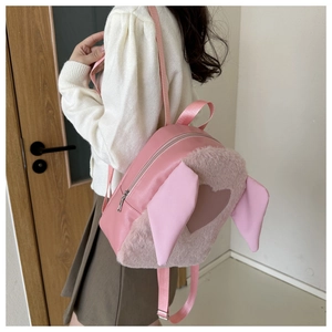 Detailed back view of pink plush backpack with long rabbit ears and heart patch on a model