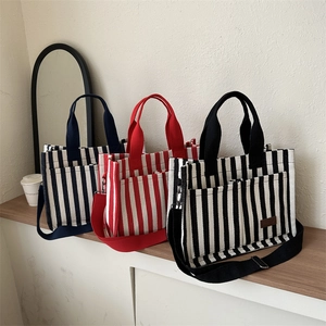 Striped canvas tote bag in black, red, and navy blue with fashion patch and shoulder strap