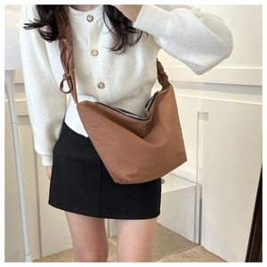 Close-up of deep brown canvas half-moon crossbody bag with durable black metal zipper