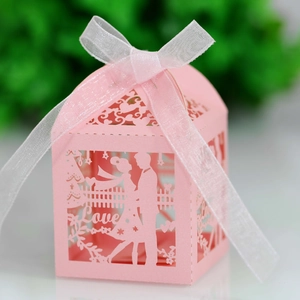 Detail of pink laser-cut wedding favor box with Love text, bride and groom silhouettes