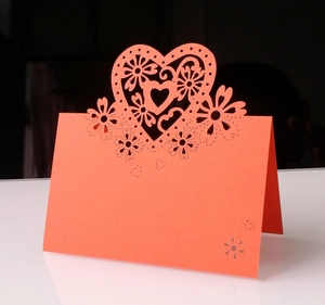 Dettaglio macro del segnaposto rosa corallo tagliato al laser con cuore e fiori cavi