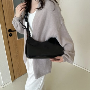Elegante schwarze Achseltasche mit gerafftem Trageriemen und Schleife an Model
