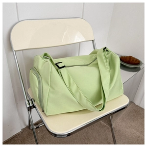 Detail of mint green oxford cloth tote bag featuring a side pocket and smooth zipper