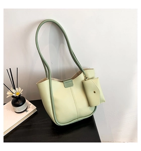 Detail of light green minimalist tote bag set with contrasting green edges and long handles