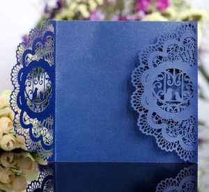 Detailed laser-cut dark blue lace wedding invitation card with elegant bird motif