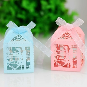 Detail of laser-cut candy box with couple silhouette and elegant silk ribbon bow