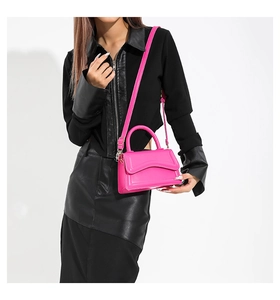 Chic rose pink mini square bag in glossy leather worn with stylish black outfit