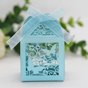 Detail of laser cut wedding favor box with blue glitter paper and organza ribbon bow