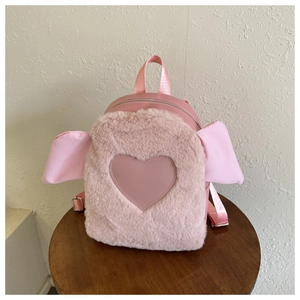 Detailed view of pink faux fur backpack featuring a leather heart and decorative ears