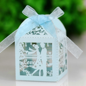 Detail of light blue laser-cut wedding favor box with Love text and ribbon bow