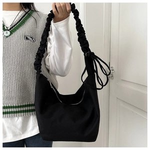 Detail of black canvas hobo bag featuring a unique gathered drawstring shoulder strap