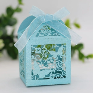 Detailed laser-cut light blue wedding favor box with butterfly patterns and ribbon bow