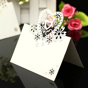 Laser cut white heart wedding place cards with floral hollow design for table setting