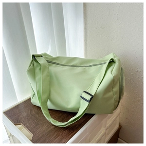 Detail der hellgrünen Oxford-Reisetasche mit verstellbarem Gurt auf einem Holztisch