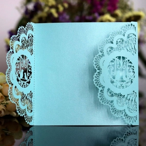 Elegant laser-cut light blue wedding invitation cover with intricate lace pattern