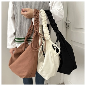 Detail of ruffle shoulder strap and drawstring design on canvas dumpling bags