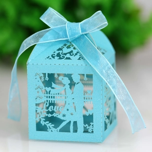 Detail of light blue laser-cut wedding favor box with Love lettering and ribbon