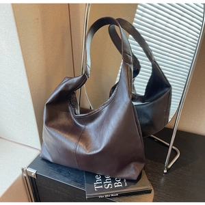 Detail of a dark coffee Hobo shoulder bag with fine leather texture and soft structure